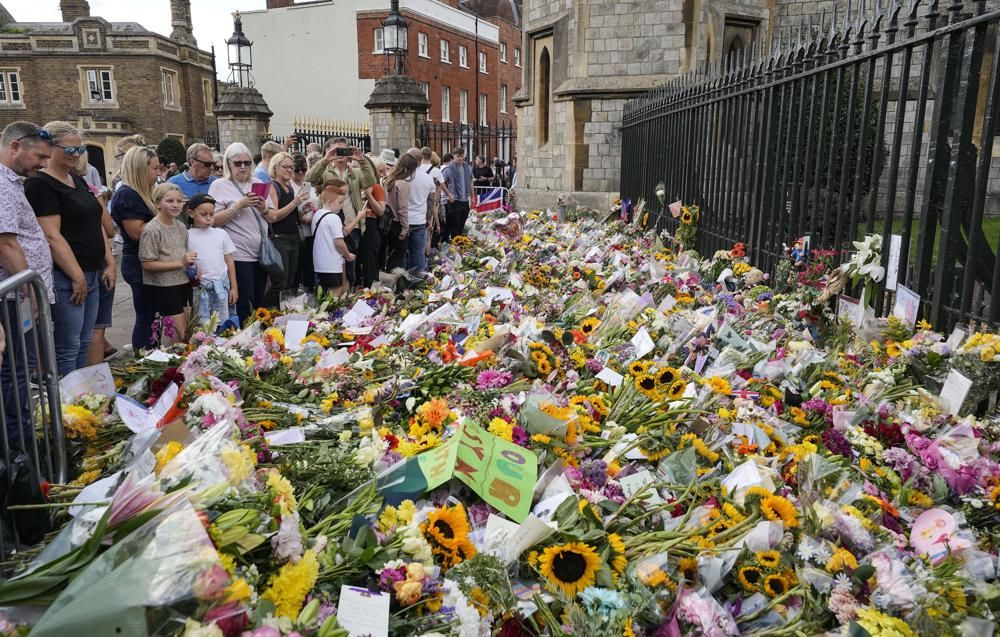 Crowds of people walk to Windsor Castle to bring flowers, in Windsor, England, Sunday, Sept. 11, 2022. Queen Elizabeth II, Britain's longest-reigning monarch died Thursday Sept. 8, 2022, after 70 years on the throne. (AP Photo/Martin Meissner)