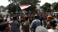 Sebagian demonstran berororasi sambil mengibarkan bendera merah putih.