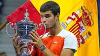 Carlos Alcaraz berpose dengan trofi juara setelah mengalahkan Casper Ruud di final tunggal putra kejuaraan tenis US Open. Di usianya yang masih 19 tahun 4 bulan, Alcaraz menjadi petenis termuda yang menduduki peringkat satu ATP (sejak 1973). Dia melewati rekor Lleyton Hewitt yang berusia 20 tahun saat jadi petenis nomor satu pada 2001. (AP/John Minchillo)