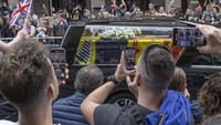 Warga berjubel untuk melihat dari dekat mobil jenazah yang membawa ratu. Iring-iringan peti jenazah ini tiba di Edinburgh setelah 6 jam perjalanan dari Kastil Balmoral. (Rasid Necati Aslim/Getty Images)  
