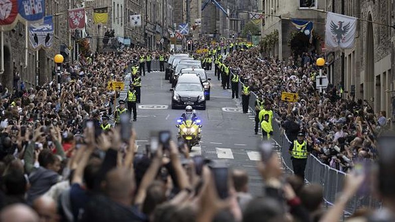 Iringan Jenazah Ratu Elizabeth II Disambut Ribuan Warga Inggris EDINBURGH, SCOTLAND - SEPTEMBER 11: The hearse carrying the coffin of Queen Elizabeth II arrives at Palace of Holyroodhouse, Edinburgh, where she will lie overnight and then be moved to St Giles Catherdral on September 11, 2022 in Edinburgh, United Kingdom. Elizabeth Alexandra Mary Windsor was born in Bruton Street, Mayfair, London on 21 April 1926. She married Prince Philip in 1947 and ascended the throne of the United Kingdom and Commonwealth on 6 February 1952 after the death of her Father, King George VI. Queen Elizabeth II died at Balmoral Castle in Scotland on September 8, 2022, and is succeeded by her eldest son, King Charles III.