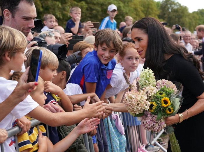 Meghan Markle di Windsor Castle WINDSOR, ENGLAND - SEPTEMBER 10: Prince Harry, Duke of Sussex, and Meghan, Duchess of Sussex arrive on the long Walk at Windsor Castle arrive to view flowers and tributes to HM Queen Elizabeth on September 10, 2022 in Windsor, England. Crowds have gathered and tributes left at the gates of Windsor Castle to Queen Elizabeth II, who died at Balmoral Castle on 8 September, 2022. (Photo by Chris Jackson/Getty Images)