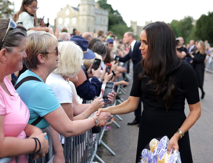 Meghan Markle di Windsor Castle WINDSOR, ENGLAND - SEPTEMBER 10: Prince Harry, Duke of Sussex, and Meghan, Duchess of Sussex arrive on the long Walk at Windsor Castle arrive to view flowers and tributes to HM Queen Elizabeth on September 10, 2022 in Windsor, England. Crowds have gathered and tributes left at the gates of Windsor Castle to Queen Elizabeth II, who died at Balmoral Castle on 8 September, 2022. (Photo by Chris Jackson/Getty Images)