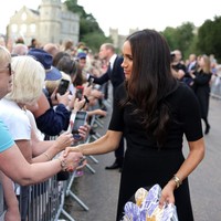 Meghan Markle terlihat menyapa publik dan mengobrol dengan beberapa penggemar kerajaan di luar kastil yang ikut berkabung atas wafatnya Ratu Elizabeth II. Foto: Getty Images/Chris Jackson