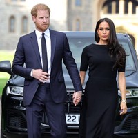 Meghan Markle tampil dengan gaun hitam panjang berpotongan A-line, dilengkapi stocking dan sepatu berwarna senada. Foto: Getty Images/Chris Jackson