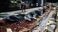 Proyek galian kabel optik mengambil sebagian jalur pedestrian di  Jalan Sudirman, Jakarta Pusat, Senin (12/09/2022).