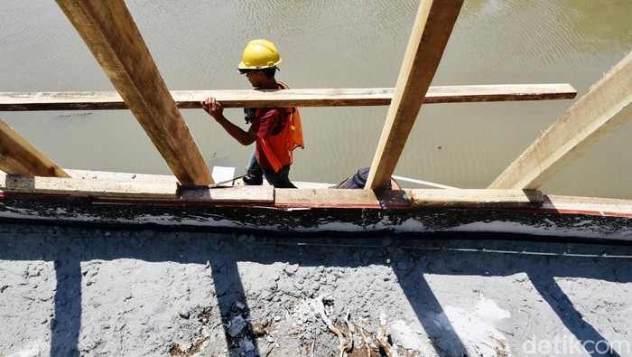 Sejumlah pekerja terus menyelesaikan pengerjaan proyek pembangunan turap pada Anak Kali Ciliwung di kawasan Pasar Baru, Jakarta Pusat, Senin (12/09/2022).