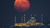 Bulan purnama muncul di atas Masjid Grand Camlica, Istanbul, Turki, Minggu (11/9/2022).