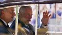Raja Charles III menyapa para pendukungnya saat tiba di Istana Buckingham di London, Minggu, (11/9/2022). (AP/Emilio Morenatti)