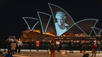 Orang-orang menyaksikan Sydney Opera House yang diterangi untuk menghormati Ratu Elizabeth II. Banyak orang menganggap rasa hormat dan kasih sayang warga Australia kepada mendiang Ratu Elizabeth II sebagai hambatan terbesar bagi negara itu untuk menjadi sebuah republik dengan kepala negaranya sendiri. 