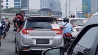 Ada yang sengaja keluar dari jendela dan duduk untuk mengabadikan konvoi dengan kamera ponsel. Mereka yang keluar dari jendela itu mengarahkan kendaraan lain untuk jalan ke kiri. (Dok. Istimewa)