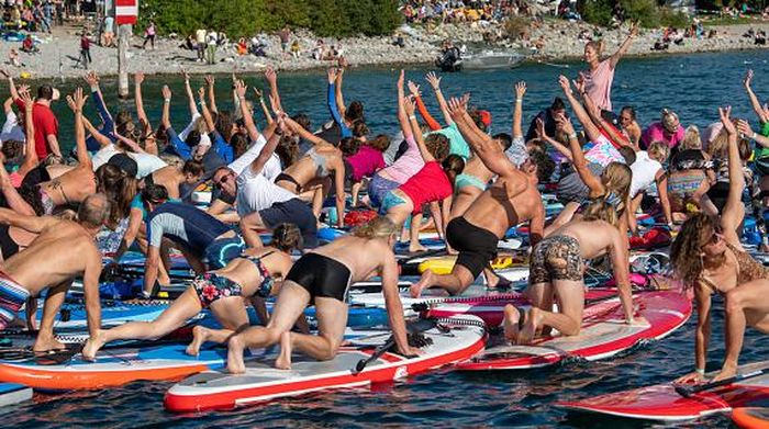 11 September 2022, Baden-Wuerttemberg, Überlingen: During a yoga class on Lake Constance, participants complete their exercise on stand-up paddles (SUPs). With 305 participants, they set a new world record. Photo: Stefan Puchner/dpa (Photo by Stefan Puchner/picture alliance via Getty Images)