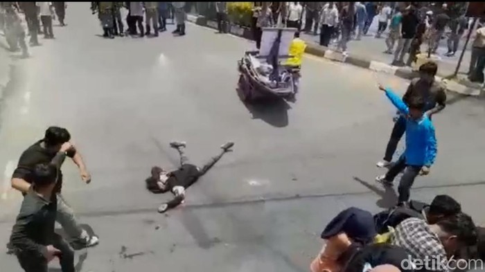 Seorang pendemo terkapar ditembak gas air mata di Aceh.