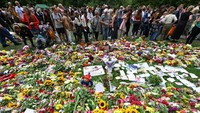 Deretan bunga ditempatkan oleh simpatisan untuk mengenang Ratu Elizabeth II di Green Park di London, Minggu (11/9/2022). (Sebastien Bozon/AFP/Getty Images)