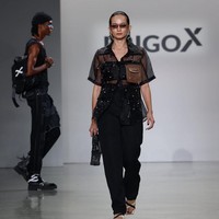 Enzy Storia tampil simpel dalam balutan kemeja transparan yang dipadu crop top, celana hitam serta sepatu sandal. Rambutnya ditata sleek ke belakang sementara wajah dipulas makeup dengan efek glossy. Foto: Instagram/@erigostore