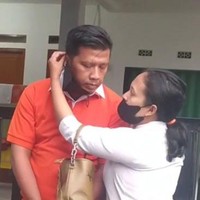 Dalam video viral terlihat sang suami meniru gaya Ferdy Sambo yang tangannya sedang terikat dilengkapi dengan kaus oranye ala tahanan.  Sedangkan sang istri memakai kemeja putih dan membawa tas. Ia juga meniru gaya Putri Candrawathi yang memasangkan masker untuk suami.  Foto: Dok. TikTok @rikasaerik.