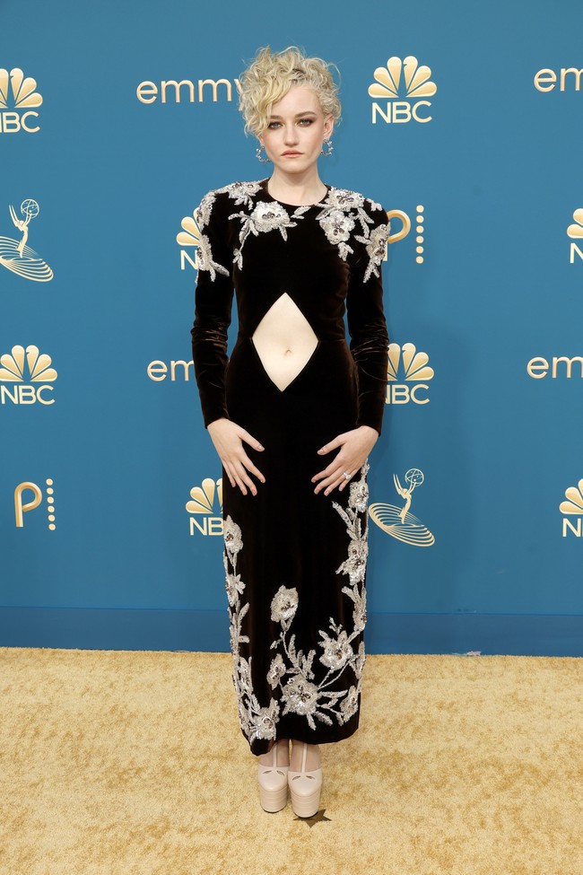 Julie Garner mencuri atensi dengan gaun velvet hitam Gucci berhiaskan embellishment. Gaun hadir dengan detail cut-out yang mengekspos perut pemeran Anna Sorokin di serial Netflix Inventing Anna. (Foto: Getty Images/Frazer Harrison)