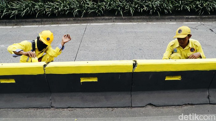 Biar Kinclong, Separator Jalan Gatsu Dicat Ulang Petugas Suku Dinas Bina Marga Jakarta Pusat, mengecat pembatas jalur bus transjakarta di Jalan Gatot Subroto, Jakarta, Selasa (13/09/2022).