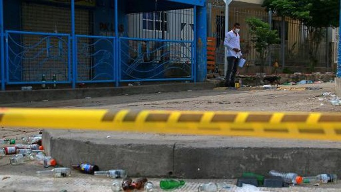 A member of the Colombian scientific police inspects outside the bar where six people were murdered by armed men at Las Flores neighborhood in Barranquilla, on September 12, 2022. - At least 15 people were killed over the last two days in Colombia in a spate of violent incidents, authorities said, highlighting the huge task facing President Gustavo Petro. In the northern city of Barranquilla, six people were shot dead by gunmen on Monday morning while drinking in a bar. (Photo by Jesus RICO / AFP)