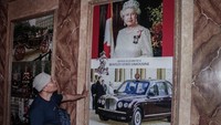 Pengunjung melihat poster Ratu Elizabeth II. Replika Istana Buckingham ini memiliki koleksi puluhan poster ratu, pangeran, dan keluarga kerajaan Inggris, dari misa Ratu Anne Stuart pada tahun 1707 hingga Pangeran Charles III.