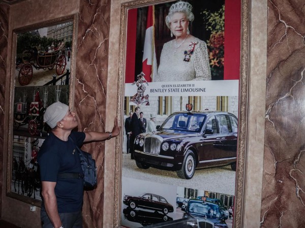 Pengunjung melihat poster Ratu Elizabeth II. Replika Istana Buckingham ini memiliki koleksi puluhan poster ratu, pangeran, dan keluarga kerajaan Inggris, dari misa Ratu Anne Stuart pada tahun 1707 hingga Pangeran Charles III. Pengunjung melihat poster Ratu Elizabeth II. Replika Istana Buckingham ini memiliki koleksi puluhan poster ratu, pangeran, dan keluarga kerajaan Inggris, dari misa Ratu Anne Stuart pada tahun 1707 hingga Pangeran Charles III.
