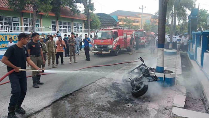 Petugas Damkar Karanganyar saat memadamkan motor yang terbakar di depan SMPN 4 Karanganyar, Selasa (13/9/2022)