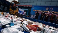 Pemusnahan barang dilakukan dengan cara dipotong, dibuang ke dalam tong dan dilindas alat berat.