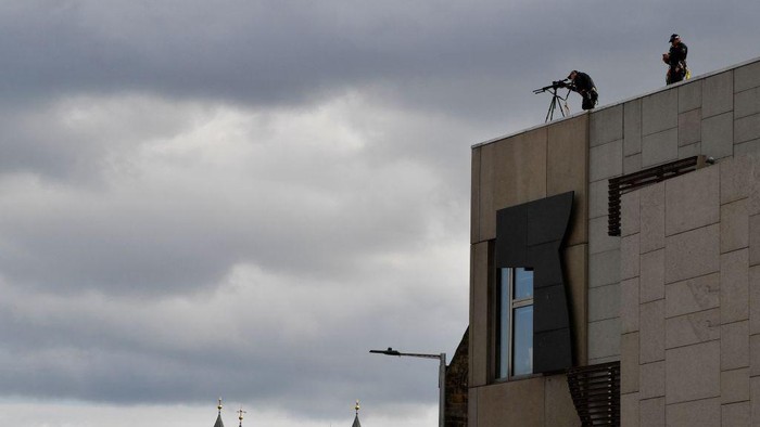 Members of security with snipers are picture on the roof of a building by the Palace of Holyroodhouse, in Edinburgh on September 11, 2022 as preparations are made for the arrival of the hearse carrying the coffin of Queen Elizabeth II. - The coffin carrying the body of Queen Elizabeth II left her beloved Balmoral Castle on Sunday, beginning a six-hour journey to the Scottish capital of Edinburgh. (Photo by LOUISA GOULIAMAKI / AFP) (Photo by LOUISA GOULIAMAKI/AFP via Getty Images)