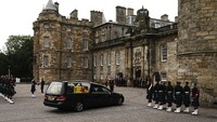 Mobil jenazah yang membawa peti mati Ratu Elizabeth II, yang dibungkus dengan Standar Kerajaan Skotlandia, menyelesaikan perjalanannya dari Balmoral ke Istana Holyroodhouse, di mana ia akan diistirahatkan selama sehari, di Edinburgh. (AP/Aaron Chown)