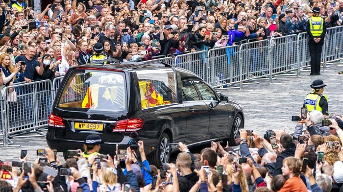 The hearse carrying the coffin of Queen Elizabeth II, draped with the Royal Standard of Scotland, passes the City Chambers on the Royal Mile, Edinburgh, Sunday, Sept. 11, 2022 on the journey from Balmoral to the Palace of Holyroodhouse in Edinburgh, where it will lie in rest for a day. (Jane Barlow/Pool Photo via AP)