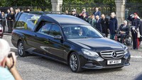 Mobil jenazah yang membawa peti mati Ratu Elizabeth II melewati Aberdeen, Skotlandia, Minggu, (11/9/2022), menuju Edinburgh. (AP/Paul Campbell)