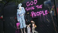 Seorang pria berjalan di dekat lukisan yang menggambarkan Ratu Inggris Elizabeth II selama Olimpiade 2012 di London, 27 Juli 2012. (AP/Daniel Ochoa de Olza)