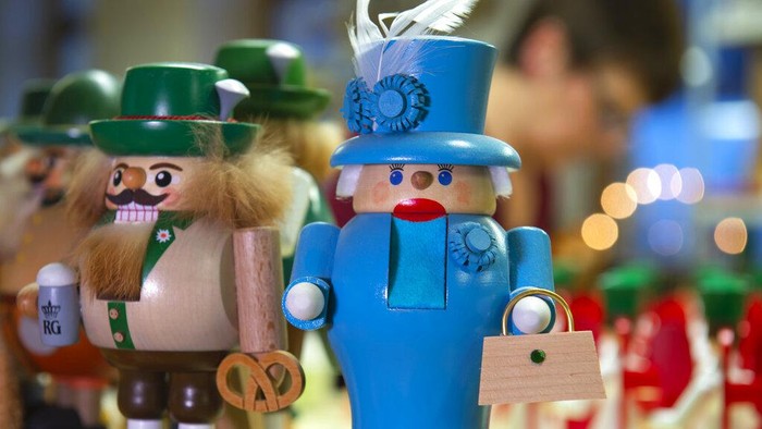A woman works behind a nutcracker displaying the British Queen Elizabeth II, right, in the Richard Glaesser company, manufacturer of traditionally hand-made wooden Christmas decoration, in the toy village Seiffen, eastern Germany, Dec. 15, 2019. (AP Photo/Jens Meyer)