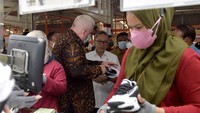 Karyawan menyelesaikan pembuatan sepatu. Sementara di belakangnya, Mendag Zulhas melihat langsung sepatu siap ekspor itu. 