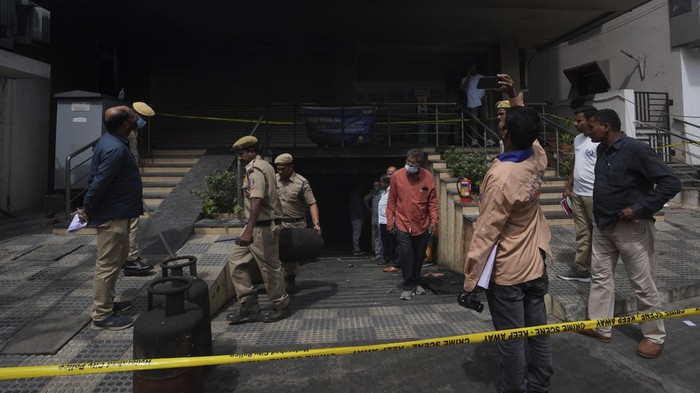 Investigators take pictures after a fire accident in an electric scooter showroom on Monday, in Hyderabad, India, Tuesday, Sept. 13, 2022. Eight people were killed and several others injured in the incident. (AP Photo/Mahesh Kumar A.)