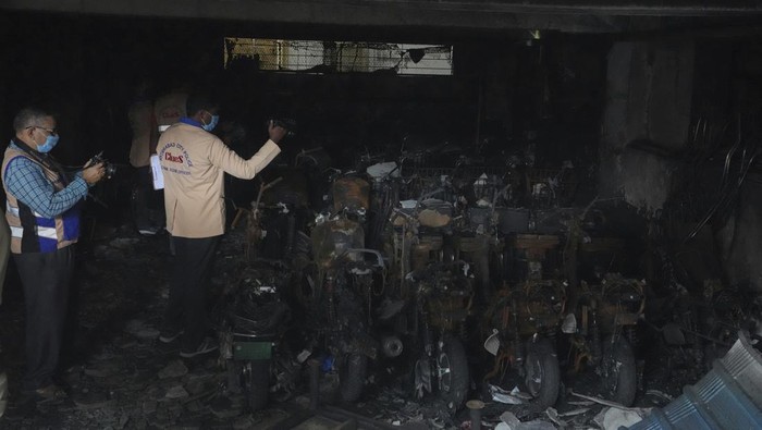 Investigators take pictures after a fire accident in an electric scooter showroom on Monday, in Hyderabad, India, Tuesday, Sept. 13, 2022. Eight people were killed and several others injured in the incident. (AP Photo/Mahesh Kumar A.)