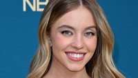 Sydney Sweeney tampil kontras dengan gaunnya yang berbunga-bunga. Foto: AFP via Getty Images/ROBYN BECK
