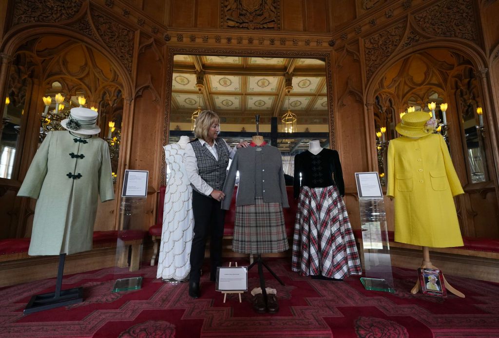 ABERDEEN, SCOTLAND - MARCH 30: Assistant curator Sarah Hoare adjusts outfits worn by Queen Elizabeth II during the opening of 