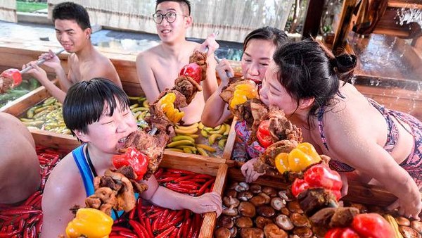 Pengunjung menikmati daging yang ditusuk sambil berenang di kolam air panas berbentuk hotpot di sebuah hotel di Hangzhou, Zhejiang, China, Minggu (27/1/2019). Pengunjung menikmati daging yang ditusuk sambil berenang di kolam air panas berbentuk hotpot di sebuah hotel di Hangzhou, Zhejiang, China, Minggu (27/1/2019).
