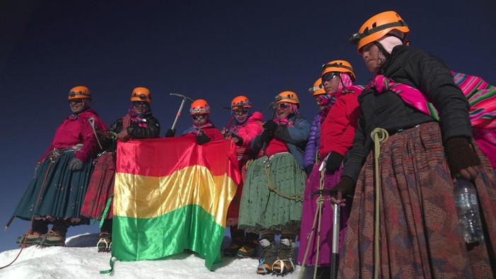 Aksi Perempuan Tangguh Suku Aymara Mendaki Gunung Bersalju di Bolivia (L-R) Juana Rufina Llusco, Senobia Llusco, Camila Tarqui Llusco, Cecilia Llusco, Adela Llusco, Erica Tinkuta, Janet Mamani and Gabriela, Aymara indigenous women members of the Climbing Cholitas of Bolivia Warmis, pose for pictures after making summit at the 6.088-metre Huayna Potosi mountain, near El Alto, Bolivia, on August 14, 2022. - The Climbing Cholitas of Bolivia Warmis is a group dedicated to campaigning for the rights of indigenous women through mountaineering. (Photo by MartΓn SILVA / AFP) (Photo by MARTIN SILVA/AFP via Getty Images)