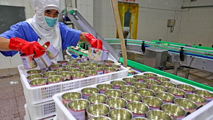 LIANYUNGANG, CHINA - SEPTEMBER 14: Staff members produce canned white peaches to be exported to Japan on the production line at a food company in the economic and technological development zone on September 14, 2022 in Lianyungang, Jiangsu Province of China. (Photo by Geng Yuhe/VCG via Getty Images)