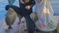 Dinda Hauw dan Rey Mbayang kompak sering liburan bersama. Ini momen keduanya saat memancing di laut. Foto: Instagram @dindahauw