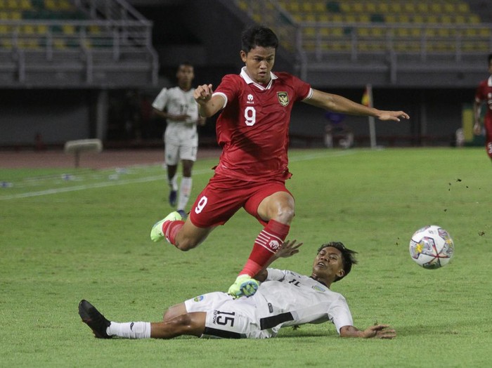Pemain tim U-20 Indonesia Hokky Caraka Brilliant (atas) melewati hadangan pemain tim U-20 Timor-Leste Willian Quintas Vong saat pertandingan kualifikasi Piala Asia U-20 2023 Grup F di Stadion Gelora Bung Tomo, Surabaya, Jawa Timur, Rabu (14/9/2022). ANTARA FOTO/Moch Asim/foc.