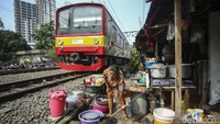 Warga beraktivitas pagi hari di samping kereta yang melintas di Benhil Jakarta. Pemerintah memperkirakan inflasi tahun ini akan bertambah 1,8% setelah kenaikan harga BBM.