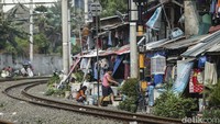 Deretan permukiman semi permanen berdiri di sepanjang bantaran rel kereta. 