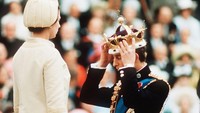 Pangeran Charles mengenakan mahkota emas dalam penobatan sebagai Pangeran Wales di Caernarvon, Wales. Momen tersebut disaksikan langsung oleh sang ibunda. (Anwar Hussein/Getty Images)