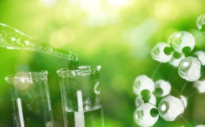 test tube and drop of water with science chemical structure on green background
