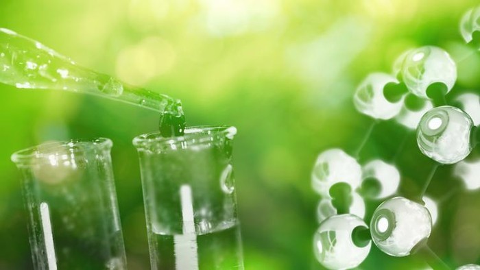 test tube and drop of water with science chemical structure on green background