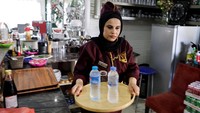 Seorang pramusaji membawa minuman untuk diantarkan ke meja konsumen. Pemilik restoran, Hamouda, mempekerjakan delapan wanita sebagai staf. 