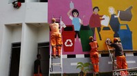 Petugas melukis mural di salah satu tembok bangunan. Kampung Gembira Gembrong ini untuk mengganti tempat tinggal korban kebakaran pada akhir April lalu. 